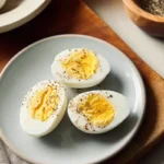 Hard boiled eggs in air fryer served on a gray plate, seasoned with black pepper