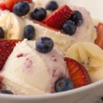 Healthy ice cream recipe made with frozen banana and milk, add on fruits, close up shot