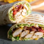 Close-up of sliced chicken bacon ranch wraps filled with juicy chicken, crispy bacon, lettuce, tomato, and creamy ranch in grilled tortillas.