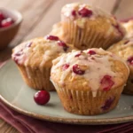 cranberry muffins with glaze on top on a plate