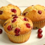 cranberry orange muffins on plate with cranberries