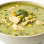 green enchilada soup with shredded chicken and cheese in bowl
