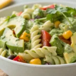 Avocado pasta salad with creamy avocado dressing, mixed vegetables, and pasta served cold in a bowl.