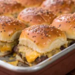 Cheeseburger sliders baked in a pan with melted cheese and sesame seed buns, served hot