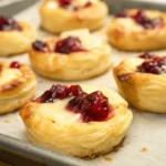 Flaky puff pastry cranberry brie bites baked until golden and served as an elegant holiday appetizer.