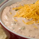 taco dip with shredded cheese tomato avocado olives