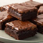 Brownies with a rich fudgy center and glossy chocolate top styled beautifully as a brownie dessert for birthdays or special occasions.