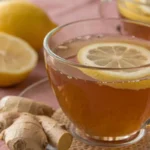 Lemon ginger tea served warm in a clear cup with fresh lemon slices and ginger creating a calm healthy drink aesthetic.