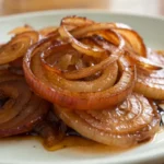 Caramelized onions cooking until golden brown, made from sliced onion using a classic caramelized onions recipe with options for grilled onions caramelized or crockpot caramelized onions.