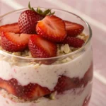 Strawberry cheesecake overnight oats layered with oats strawberries and creamy cheesecake style filling prepared as a healthy breakfast meal prep.