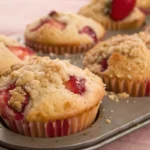 Strawberry muffins baked until golden with fresh strawberries inside shown as soft homemade fruit muffins.