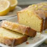 Lemon loaf cake sliced on a serving plate with a glossy lemon glaze on top, showing a moist golden crumb, perfect for sweet baked dessert recipes and easy homemade baking.