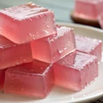Pink gelatin trick recipe in a glass serving dish, creamy and wobbly, made with protein-rich gelatin and sugar-free ingredients, perfect for a clean eating dessert or snack.