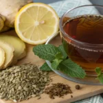 ultra-close up shot of anti bloating tea, some ginger some fennel seeds and peppermint and lemon next to the tea glass