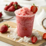 Strawberry Coconut Water Slushie served in a tall glass with fresh strawberry garnish and lime slice