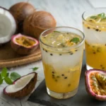 Passion Fruit Coconut Water Cooler in a glass with coconut next to it and passion fruit cut in half next to the glass