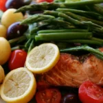 Salmon Niçoise Salad plated with roasted salmon, potatoes, green beans, eggs, and olives