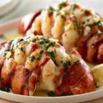 Grilled Lobster Tails with Garlic Butter plated on white dish with lemon wedges and fresh parsley