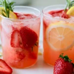 Sparkling Strawberry Lemonade in a tall glass with ice, fresh strawberries, and lemon slices on a sunny table