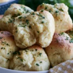 Garlic butter dinner rolls golden brown and glossy arranged on a white serving platter