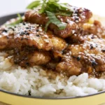 Teriyaki chicken recipe with glossy glaze served over white rice and garnished with sesame seeds and green onions