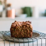 Zucchini cake recipe showing moist spiced cake slice on white plate with fork