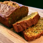 pumpkin zucchini bread sliced on wooden board with fall spices