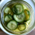Dill pickle recipe showing crisp whole pickles in a glass jar with fresh dill and garlic cloves