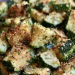 Garlic parmesan roasted zucchini with golden crispy edges and melted cheese on a white serving platter