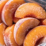 how to freeze peaches sliced and arranged on a parchment-lined baking sheet ready for freezing