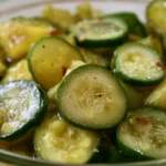 Bread and butter pickle recipe showing golden crisp pickle slices in a glass jar with visible mustard seeds