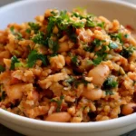 Mediterranean rice and beans served in a white bowl with fresh parsley and lemon wedges on a rustic wooden table
