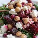 Chickpea beet feta salad served in a white bowl with vibrant magenta beets, golden chickpeas, and creamy white feta cheese
