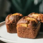 Mini banana bread loaves with toasted walnuts on a white plate