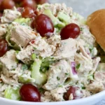 Chicken salad recipe with grapes served in a white bowl with pecans and celery