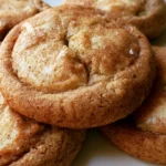 Apple cider cheesecake cookies stacked on a white plate showing soft chewy texture and cream cheese filling