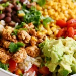 Weight watchers burrito bowls with seasoned chicken, cilantro lime rice, black beans, and fresh toppings in a white bowl
