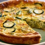 Zucchini pie with golden flaky crust and lattice top on white plate with fork