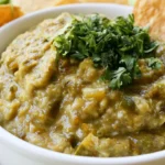 Hatch chili salsa in a white bowl with roasted green chiles and fresh cilantro