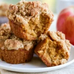 Pumpkin apple crumble muffins with golden buttery streusel topping on a rustic wooden board