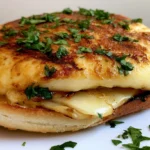Grilled Provolone Recipe showing golden caramelized cheese round bubbling in cast iron skillet with herbs
