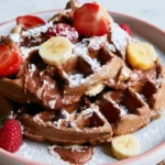 Waffle batter recipe golden brown waffles stacked on white plate with butter and maple syrup