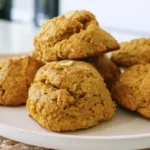 Trader Joe's pumpkin ginger scones on a white plate with glaze drizzle and warm fall spices