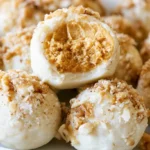 Pumpkin cheesecake truffles coated in chocolate and graham cracker crumbs on a white serving platter
