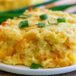 Corn pudding in a white baking dish with golden brown top and visible corn kernels