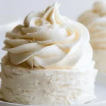Buttercream frosting recipe swirled on top of a vanilla cupcake with smooth, creamy texture