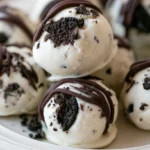 Oreo truffle recipe on a white plate with chocolate coating and crushed cookie topping