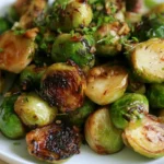 Roasted brussel sprouts on a white serving platter with golden brown crispy edges and tender centers
